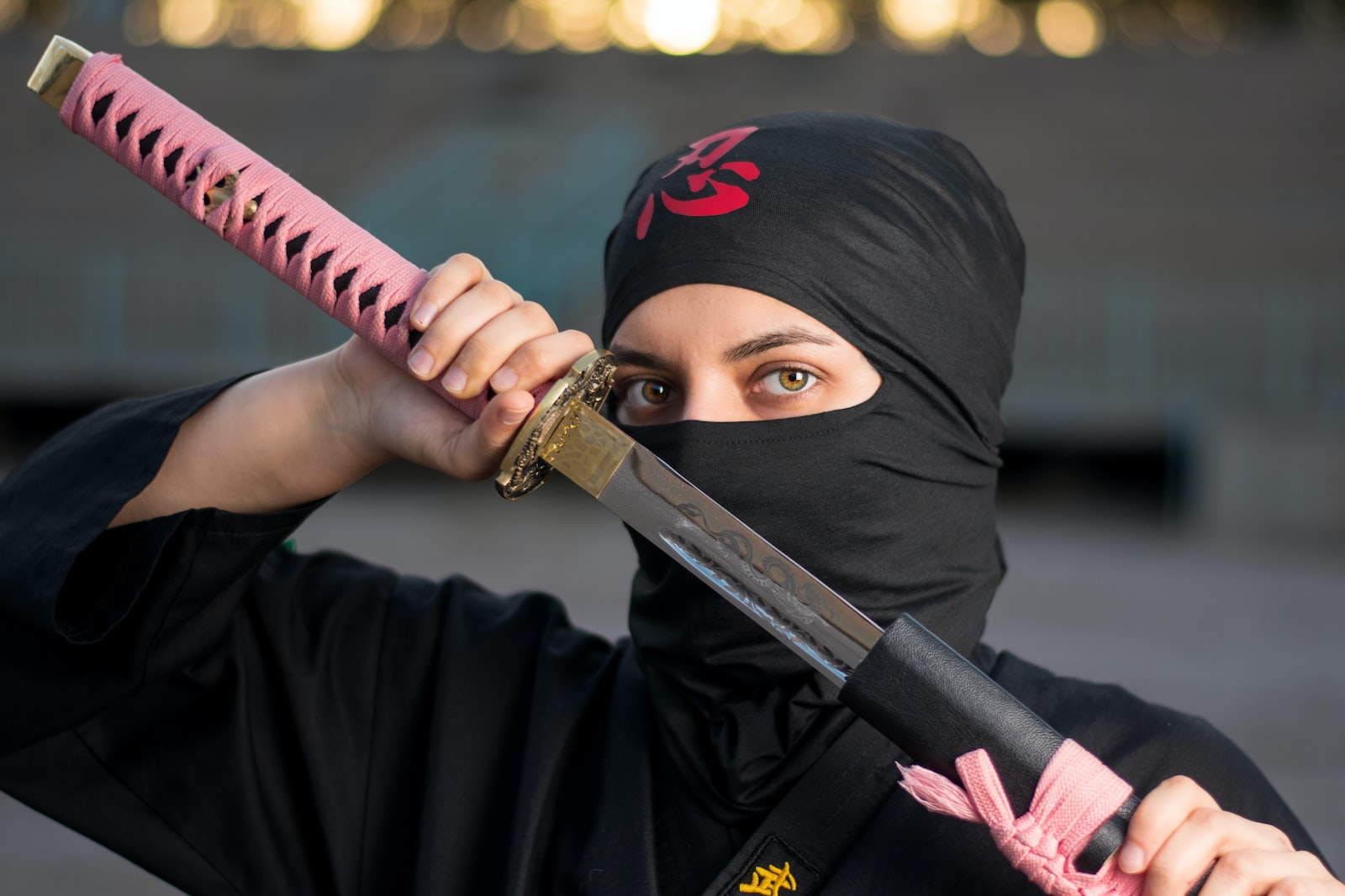 woman in black hijab holding pink and black sword