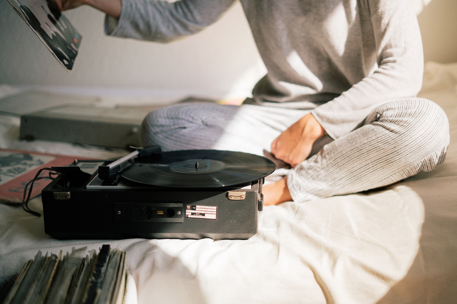 Person in Gray Sweater Holding Black Vinyl Record Player
